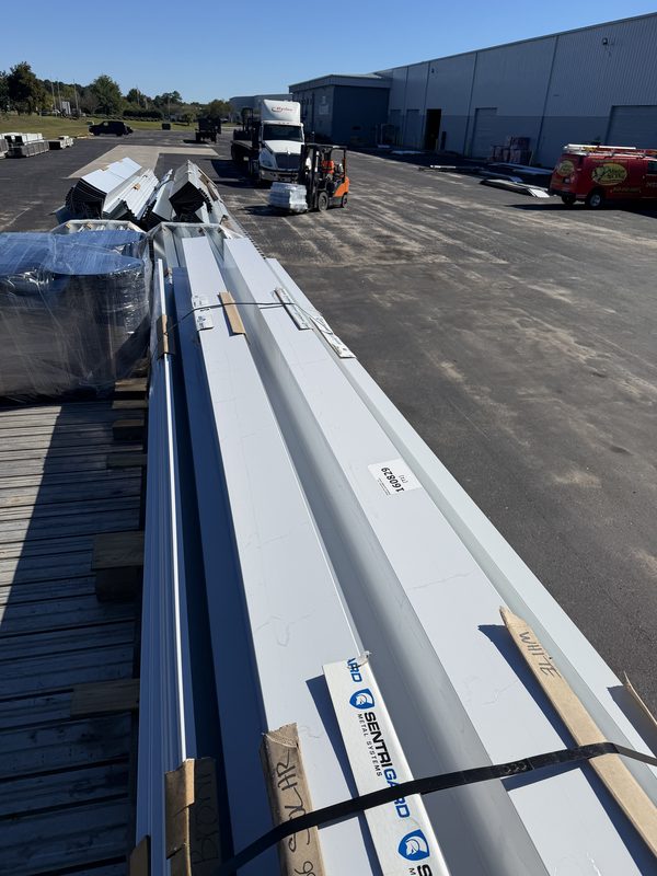 Long metal roofing panels and trim bundles banded to a flatbed deck